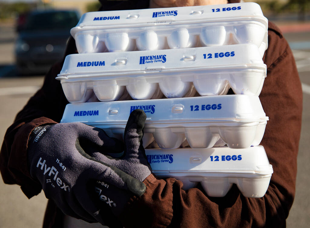 Volunteer Christina Bailey holds packs of eggs to be given away at a drive-thru distribution si ...