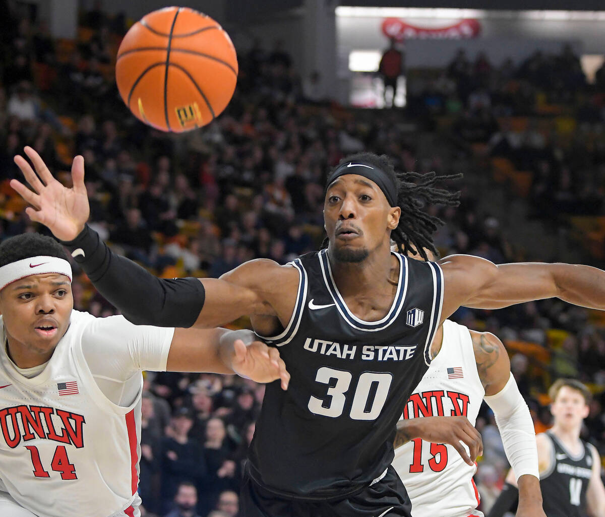 UNLV guard Keyshawn Hall (14) and Utah State forward Dan Akin (30) fight for a rebound during t ...