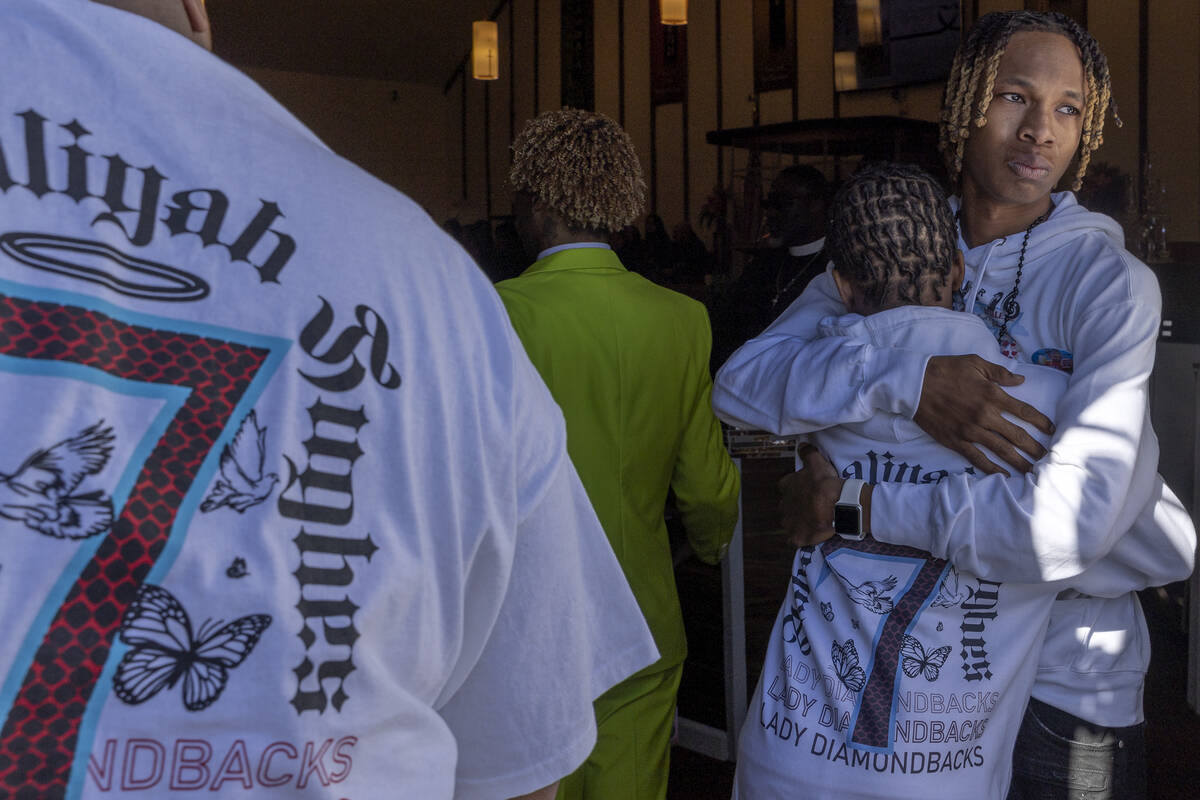 Enttroda Hughes Jr. and Josiah Hughes, brothers of Ashari Hughes, embrace as their sisterȁ ...