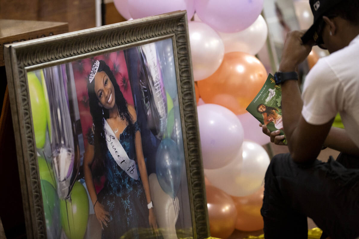 Photos of Ashari Hughes are displayed during a memorial for the 16 year old at New Bethel Bapti ...