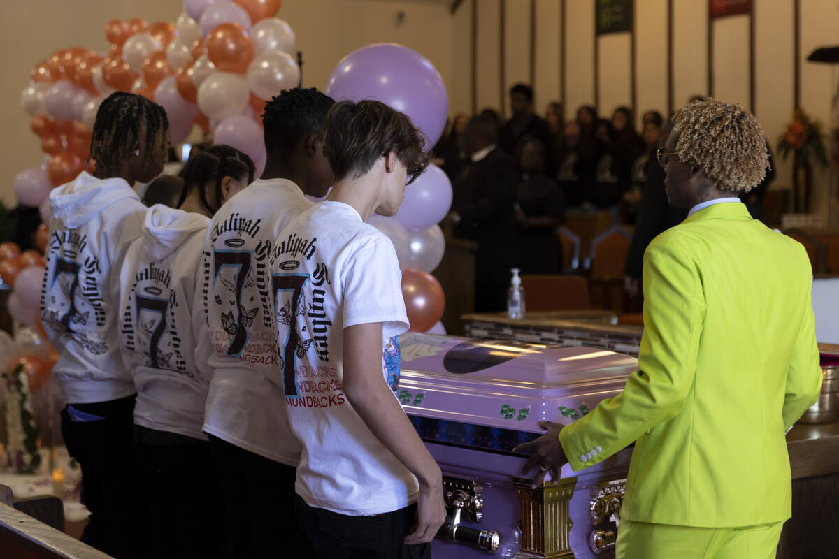 Loved ones of Ashari Hughes watch as her casket is brought in for her memorial at New Bethel Ba ...