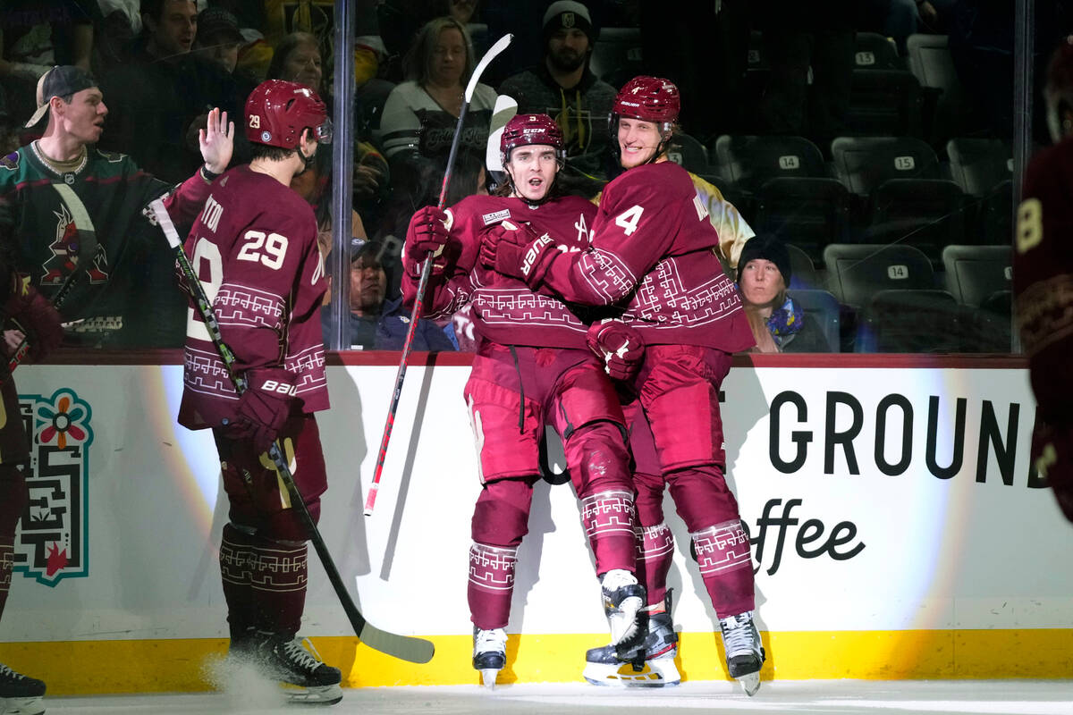 Arizona Coyotes right wing Dylan Guenther (11) and Vegas Golden Knights  right wing Reilly Smith (19) battle for position during the second period  of an NHL hockey game in Tempe, Ariz., Sunday