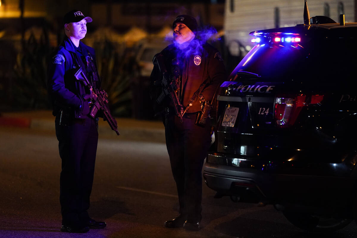Two police officers stand guard near a scene where a shooting took place in Monterey Park, Cali ...