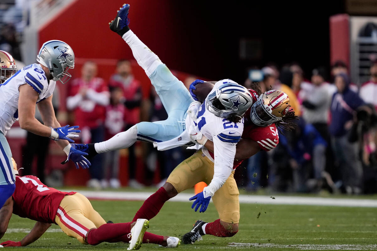 Dallas Cowboys running back Ezekiel Elliott (21) is tackled by San Francisco 49ers linebacker F ...