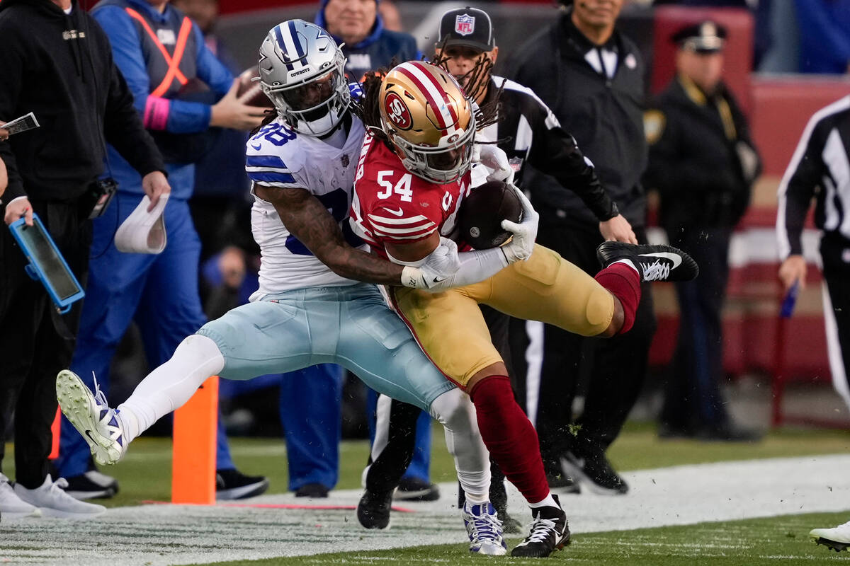 San Francisco 49ers linebacker Fred Warner (54) is tackled by Dallas Cowboys wide receiver CeeD ...