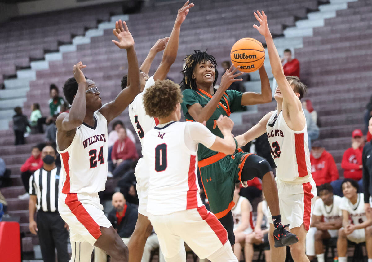Mojave's Tony Williams (10) drives to the basket through traffic during the first half of a bas ...
