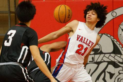 Valley's Kevan Wilkins (21) and Desert Oasis' Jaiden Fisher (11), behind, battle for a loose ba ...