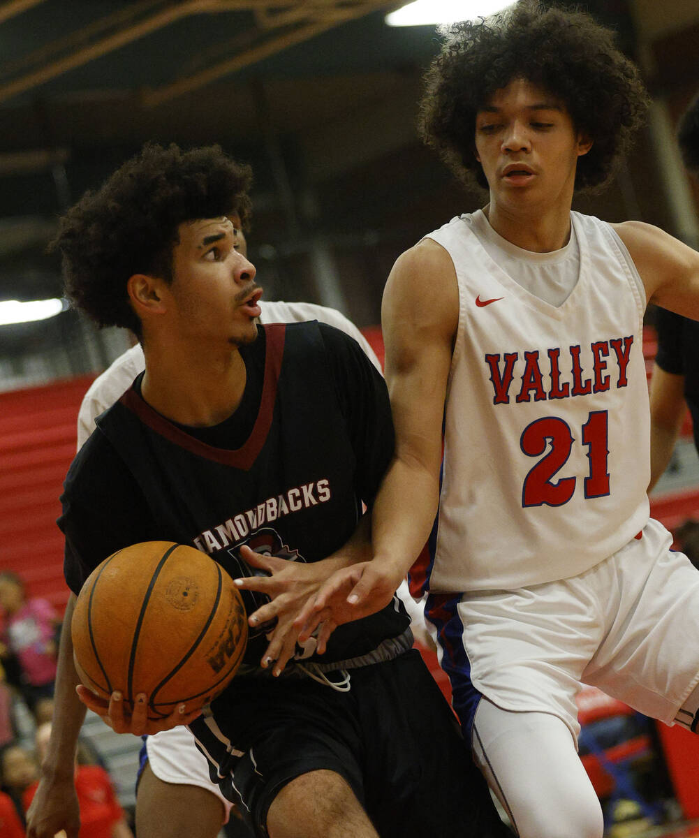 Desert Oasis' Desmond Pyre (15) keeps a ball away from Valley's Kevan Wilkins (21) during the f ...