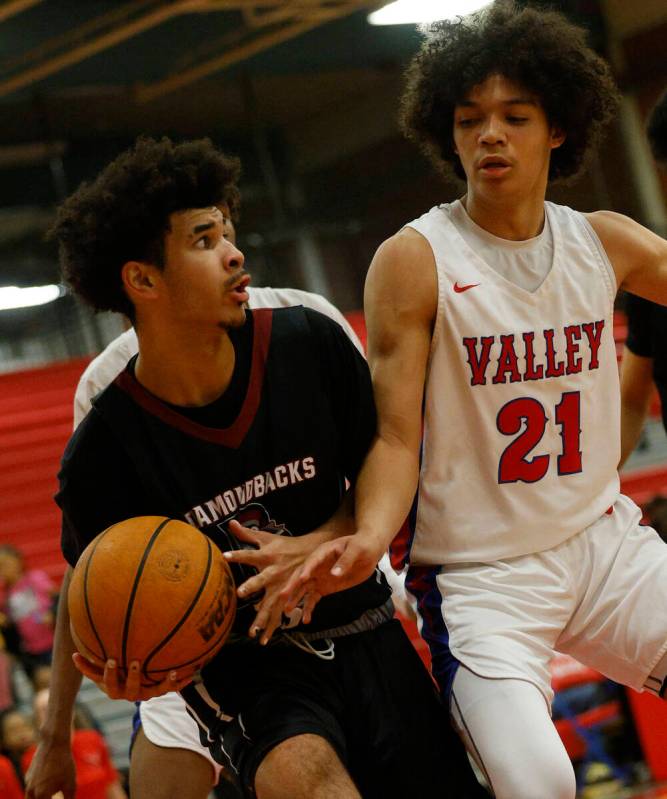 Desert Oasis' Desmond Pyre (15) keeps a ball away from Valley's Kevan Wilkins (21) during the f ...
