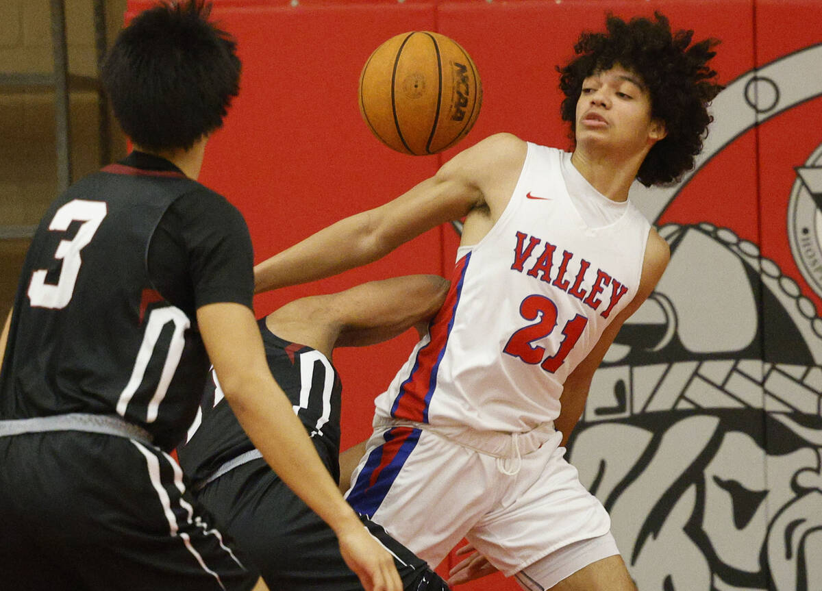 Valley's Kevan Wilkins (21) and Desert Oasis' Jaiden Fisher (11), behind, battle for a loose ba ...