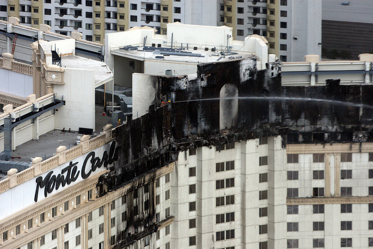 Firefighters douse hotspots on the upper floors of the Monte Carlo hotel-casino on Friday, Jan. ...