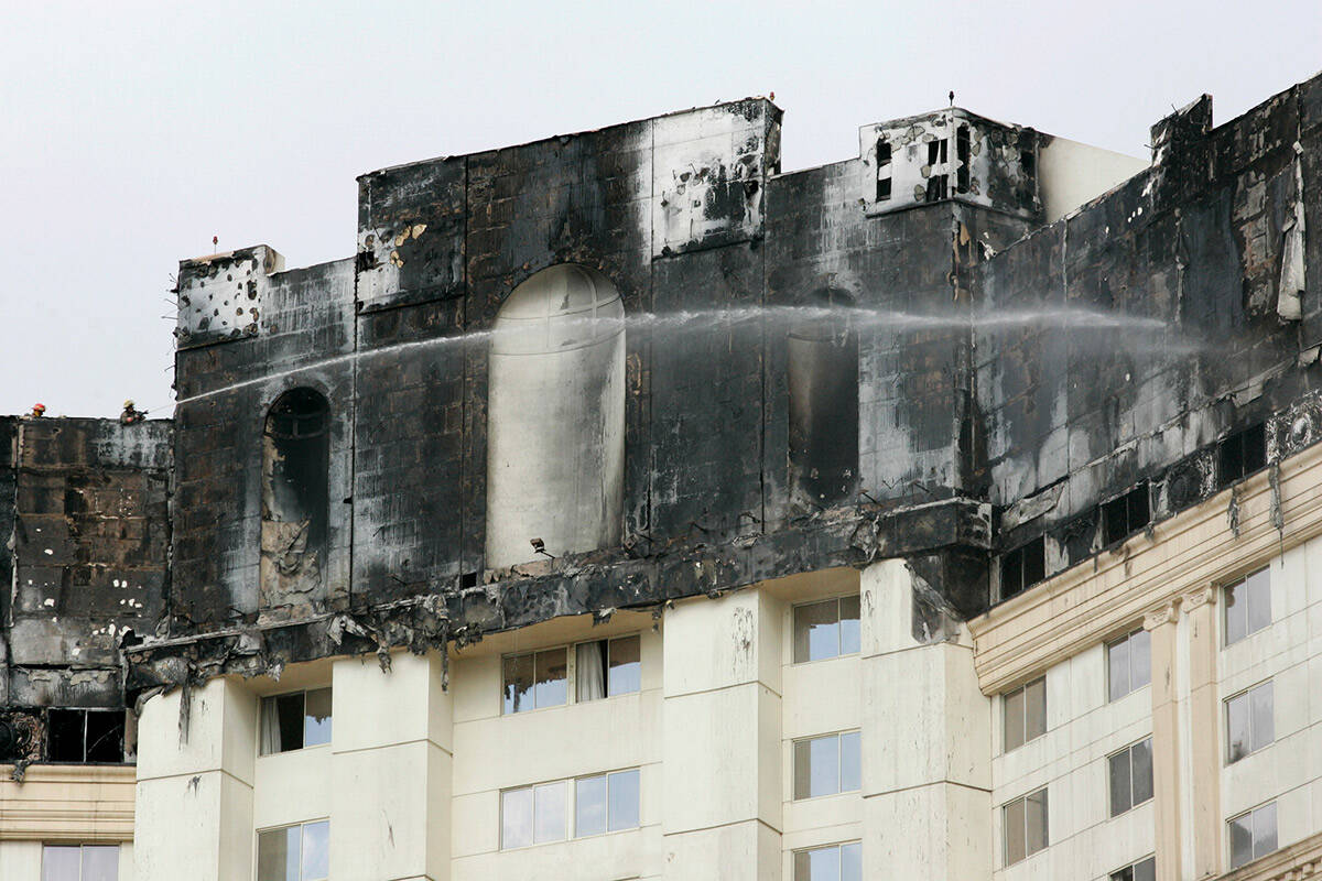 Firefighters douse hotspots on the upper level floors of the Monte Carlo hotel-casino on Friday ...