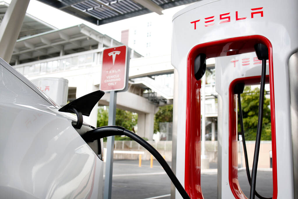 A Tesla Model 3 electric vehicle is charged at a Tesla Supercharger station near the High Rolle ...