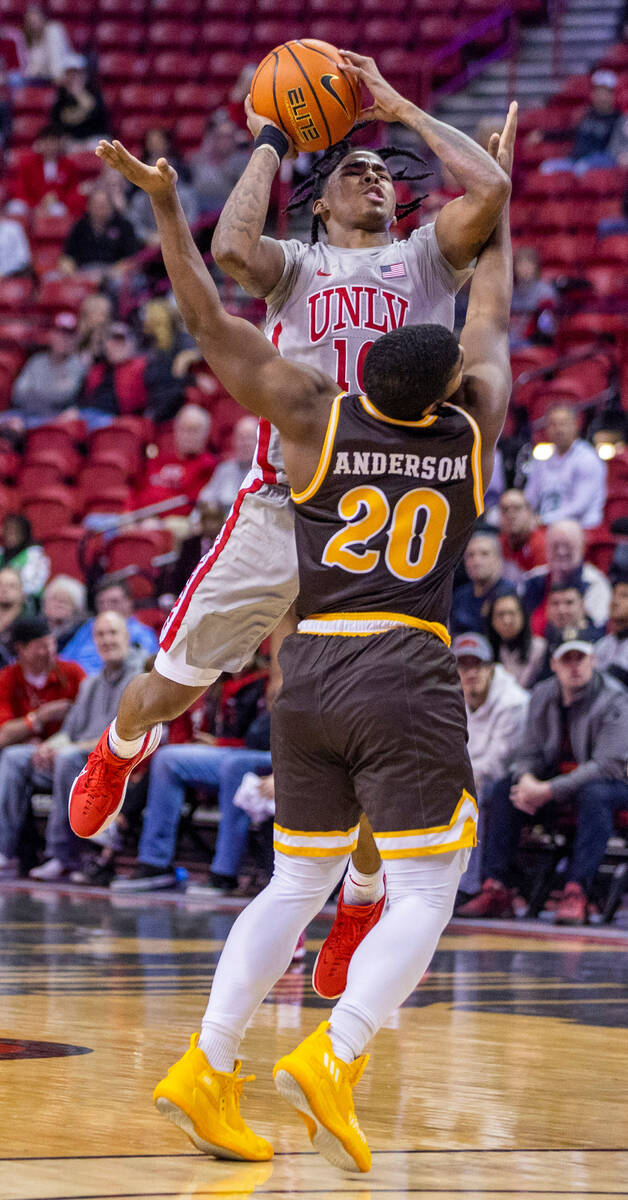 UNLV guard Keshon Gilbert (10) elevates to shoot over Wyoming guard Brendan Wenzel (20) during ...