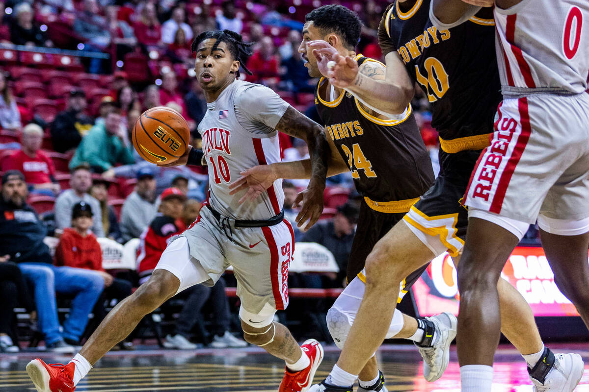 UNLV guard Keshon Gilbert (10) looks to drive past Wyoming guard Hunter Maldonado (24) during t ...