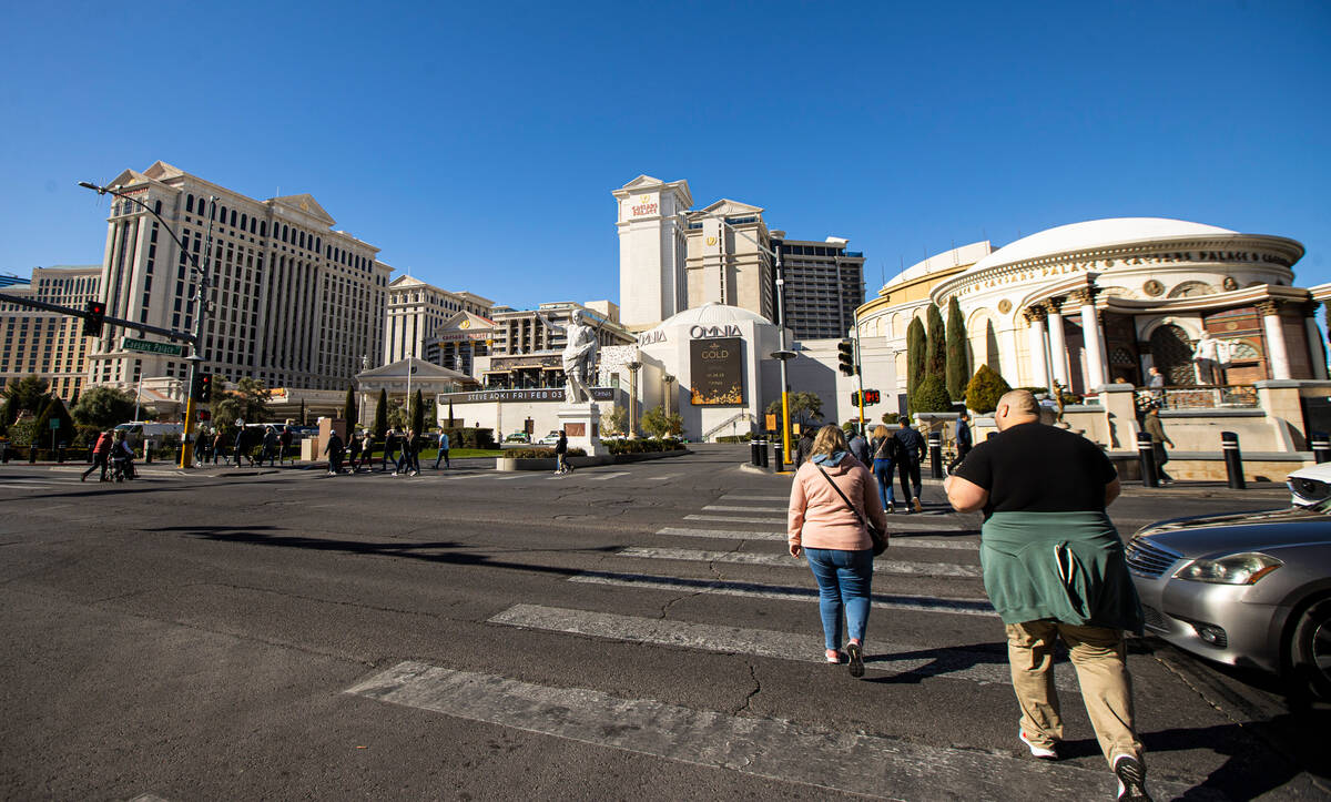 Pedestrians cross the Las Vegas Strip outside of Caesars Palace on Thursday, Jan. 26, 2023, in ...