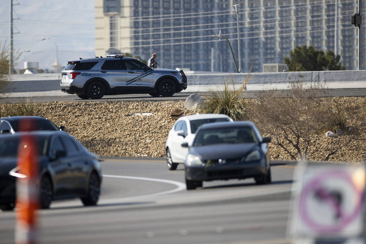 A Nevada Highway Patrol officer blocks the entrance to the I-15 freeway on Flamingo Road as con ...