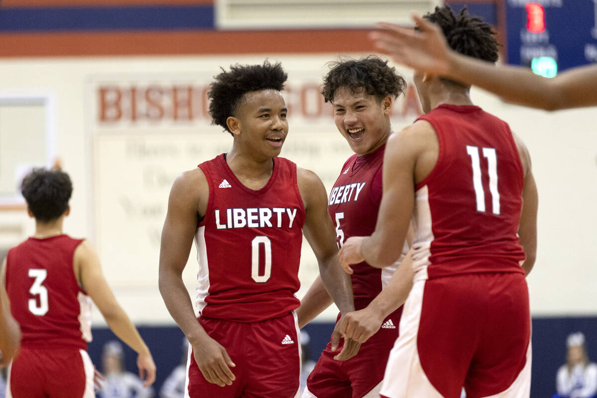 Liberty’s Tyus Thomas (0), Andre Porter (5) and Dean Thomas Jr. celebrate a foul called ...