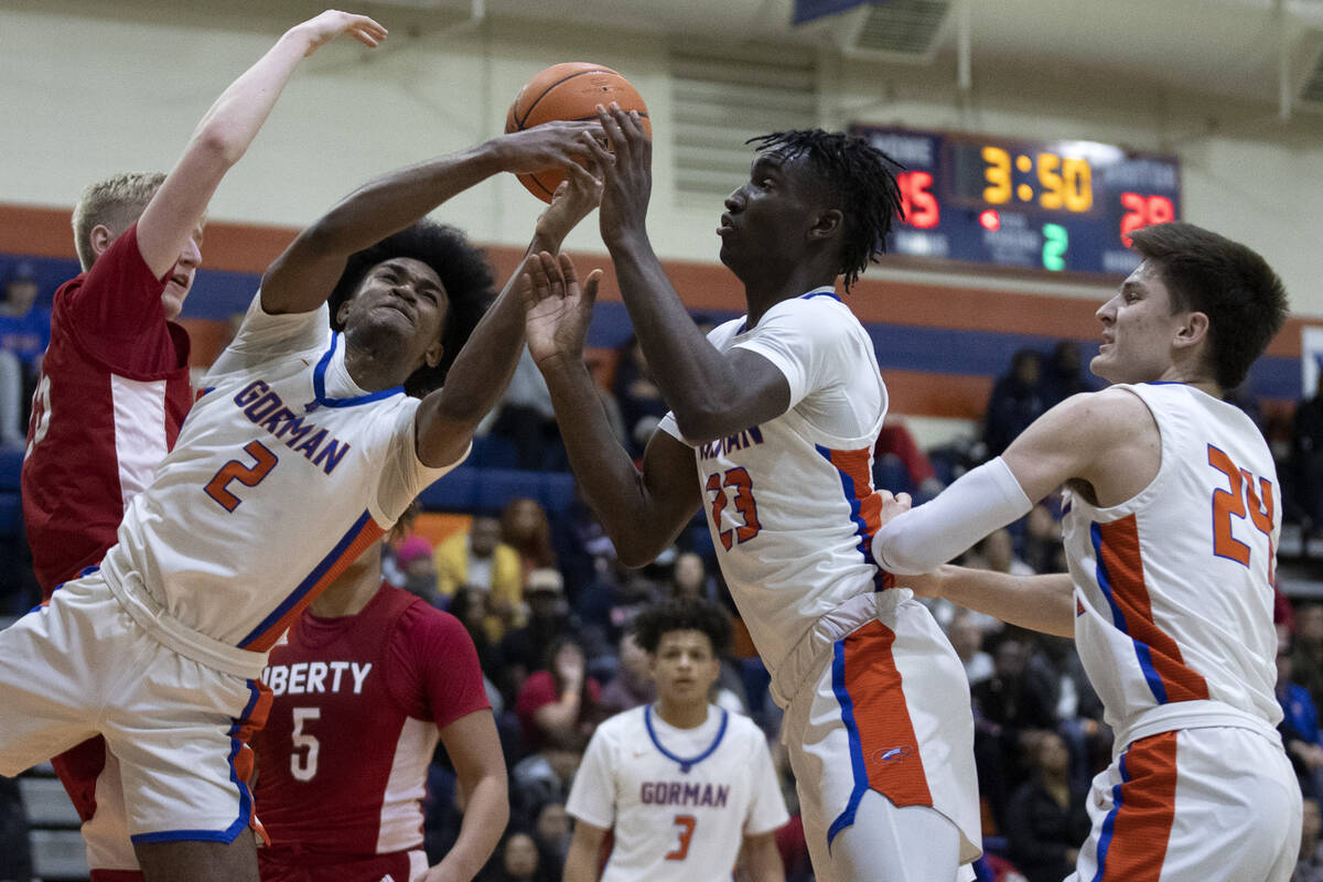 Bishop Gorman’s Keenan Bey (2) and Chris Nwuli (23) go for a rebound after Libertyȁ ...