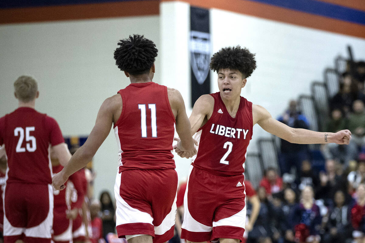 Liberty’s Angelo Kambala (2) slaps hands with his teammate Dedan Thomas Jr. (11) during ...