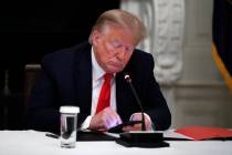 In this Thursday, June 18, 2020, file photo, President Donald Trump looks at his phone during a ...