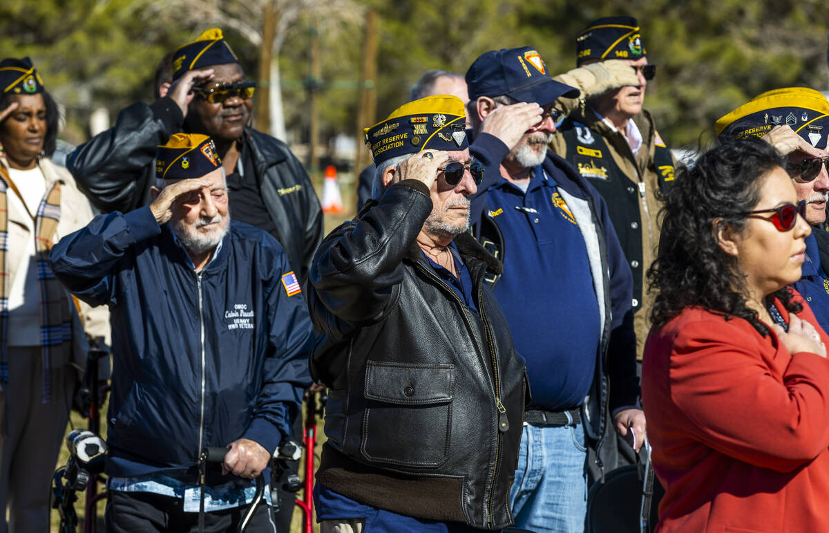 Attendees stand and salute for the Pledge of Allegiance during a groundbreaking ceremony at the ...