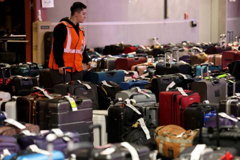 A worker looks for a passenger’s luggage from canceled and delayed flights in the Southwest b ...