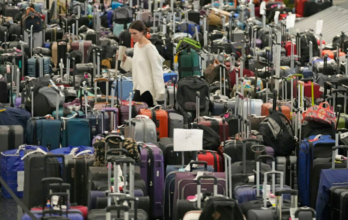 A woman walks through unclaimed bags at Southwest Airlines baggage claim at Salt Lake City Inte ...