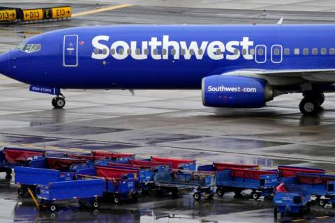 A Southwest Airlines jet passes unused luggage carts as it arrives, Dec. 28, 2022, at Sky Harbo ...