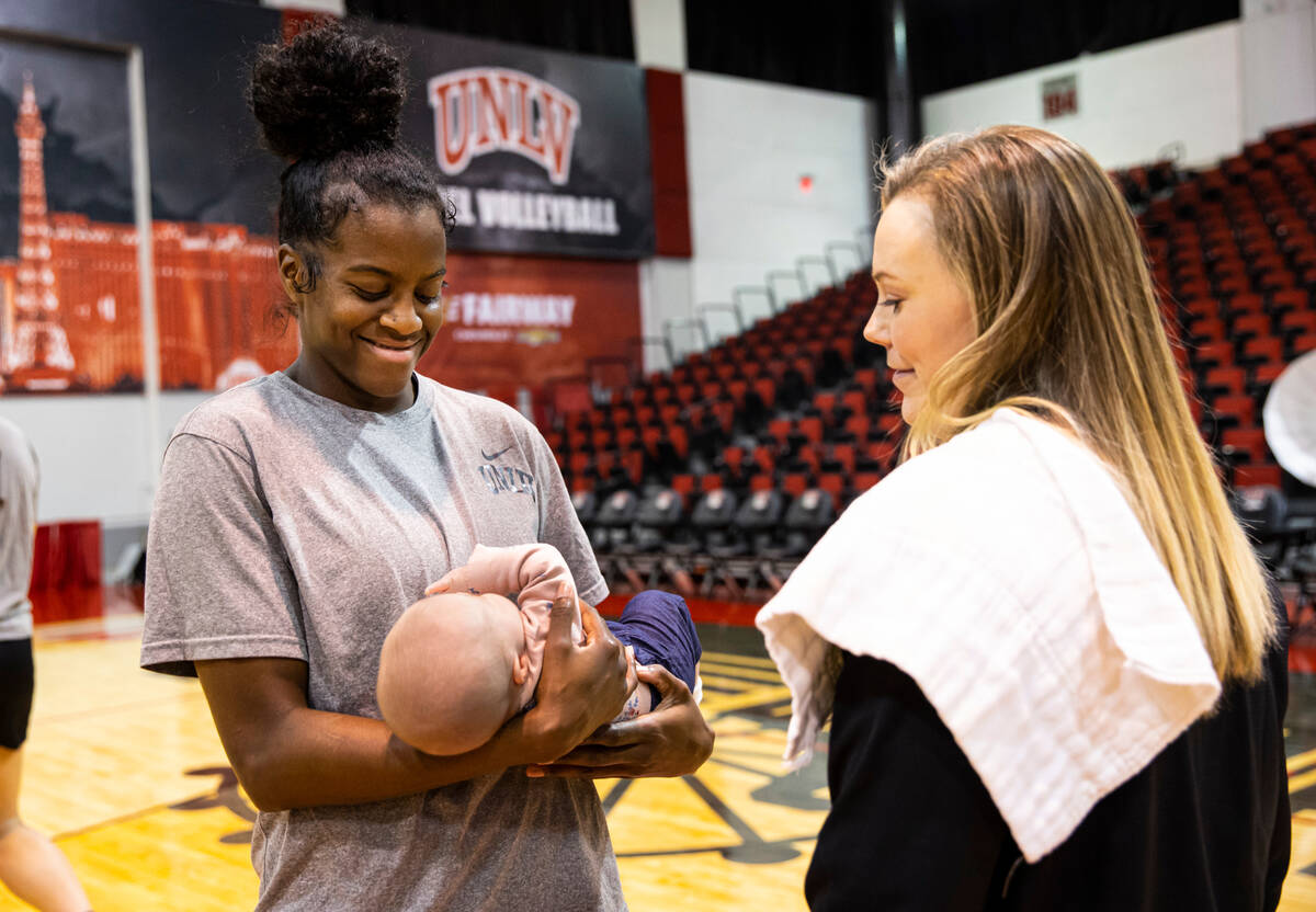UNLV center Desi-Rae Young, left, holds Ellie Cunningham, the newborn baby of UNLV Lady Rebels ...