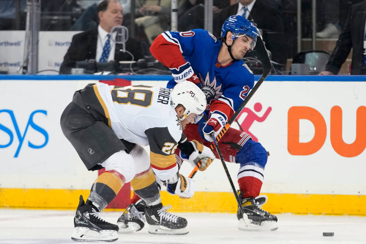Vegas Golden Knights left wing William Carrier (28) competes for the puck against New York Rang ...