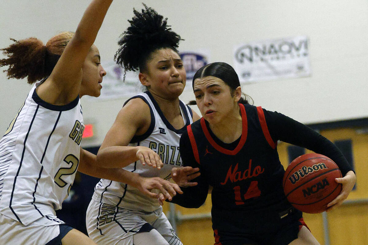 Coronado's Kaylee Walters (14) tries to drive past Spring Valley's Jada Green (23) and Spring V ...