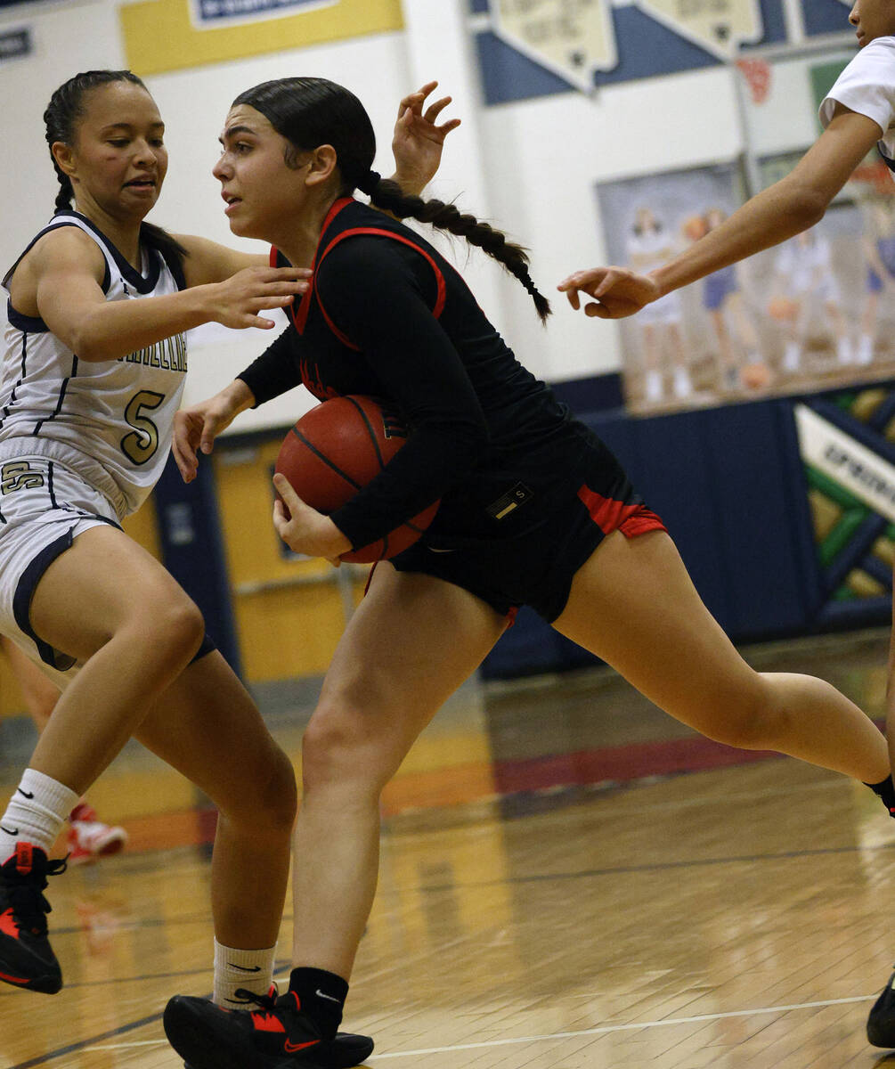 Coronado's Kaylee Walters (14), right, goes to the basket as Spring Valley's Gia McFadden (5) d ...