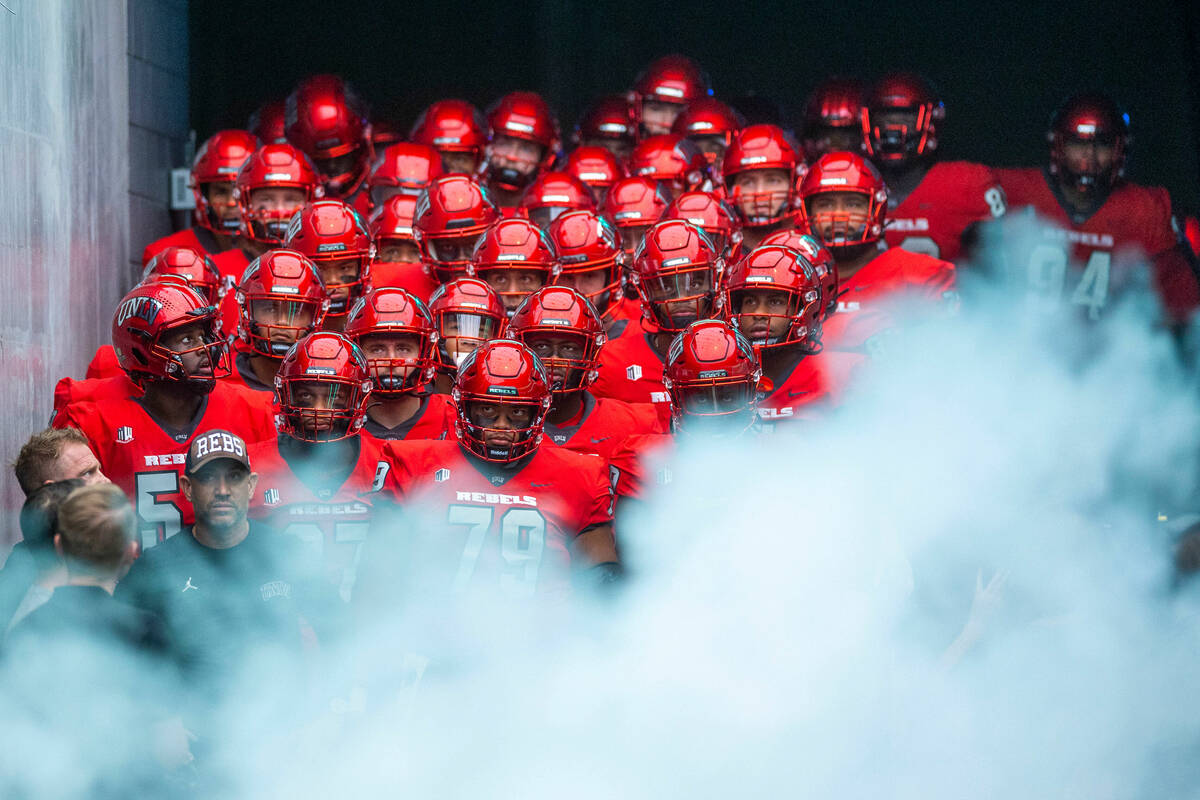 UNLV Rebels head coach Marcus Arroyo and players await to be introduced behind smoke before fac ...