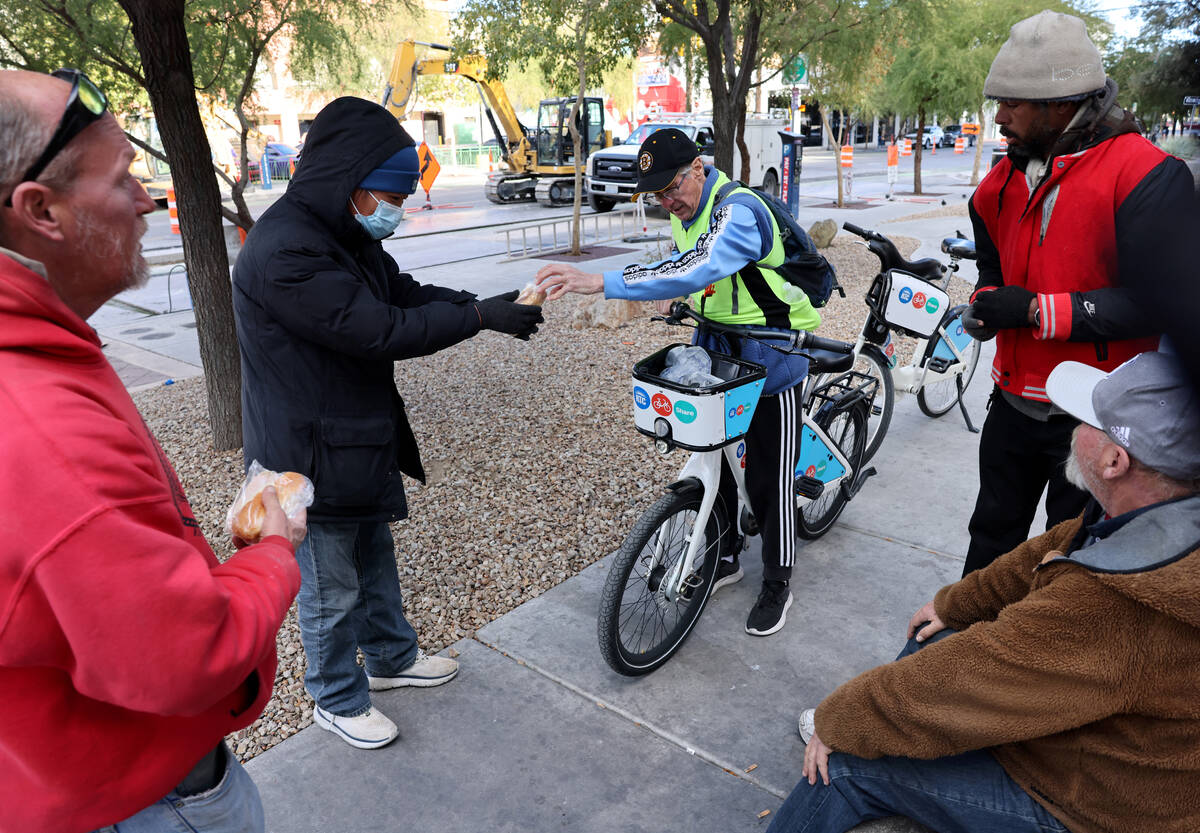 Richard Birmingham, center, offers food and resource information during his daily bicycle outre ...