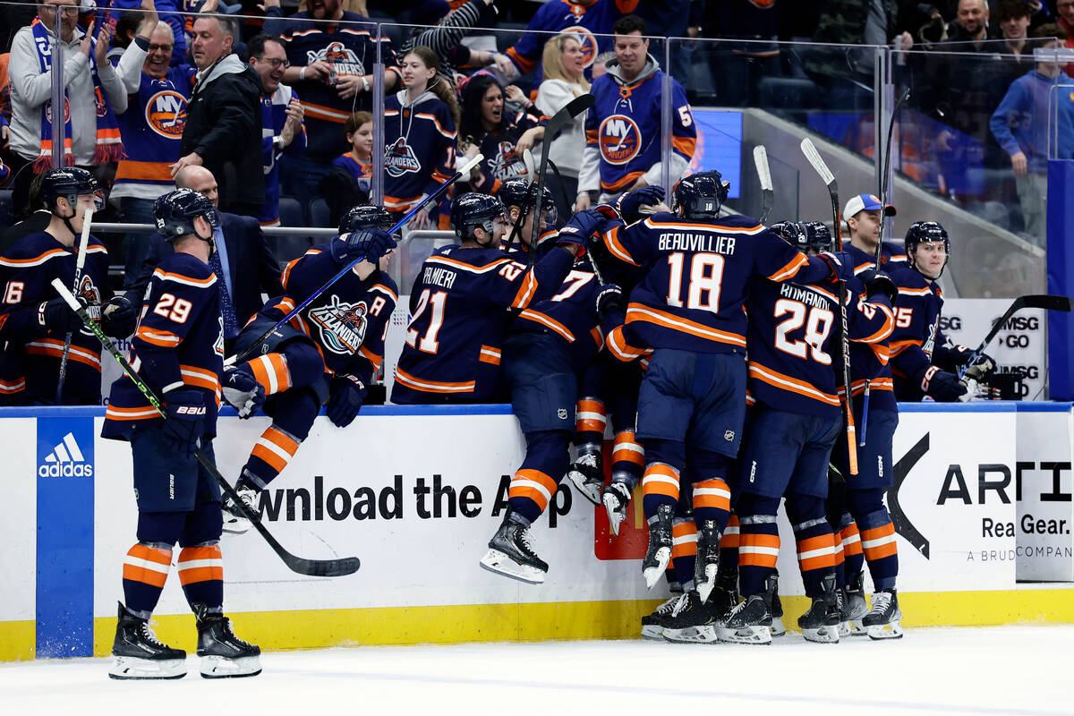 New York Islanders center Mathew Barzal (13) is congratulated by teammates after scoring the ga ...