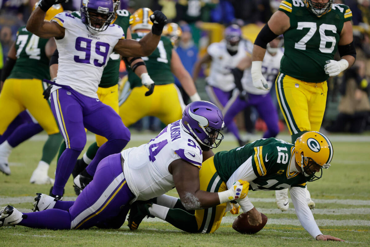 Green Bay Packers quarterback Aaron Rodgers (12) gets strip sacked by Minnesota Vikings defensi ...
