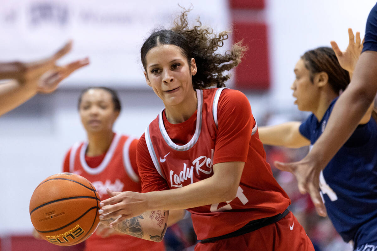 UNLV Lady Rebels guard Essence Booker (24) passes between Nevada Wolf Pack players during the s ...