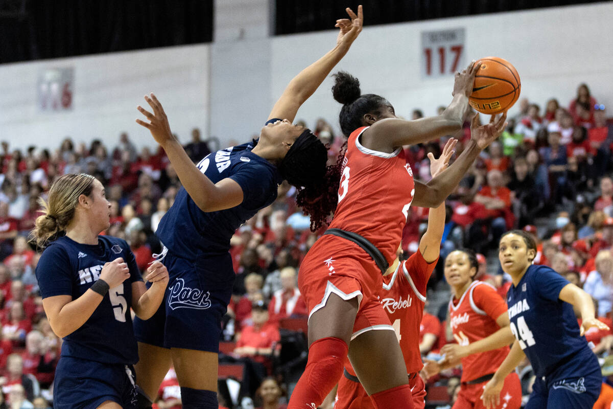 UNLV Lady Rebels center Desi-Rae Young (23) and Nevada Wolf Pack forward Lexie Givens (23) jump ...