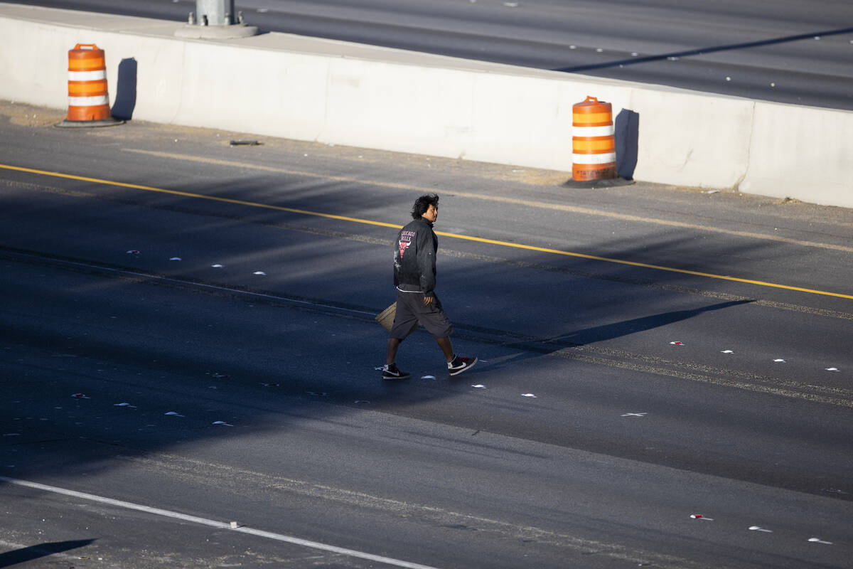 A person crosses the closed I-15 freeway between Russell and Flamingo roads near the Russell Ro ...