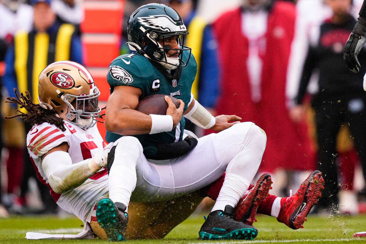 Philadelphia Eagles quarterback Jalen Hurts, right, is sacked by San Francisco 49ers linebacker ...