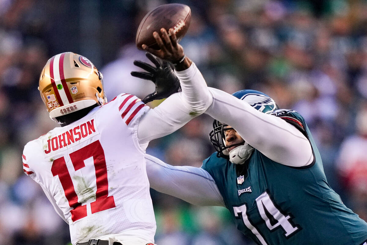 San Francisco 49ers quarterback Josh Johnson, left, attempts a pass as Philadelphia Eagles defe ...