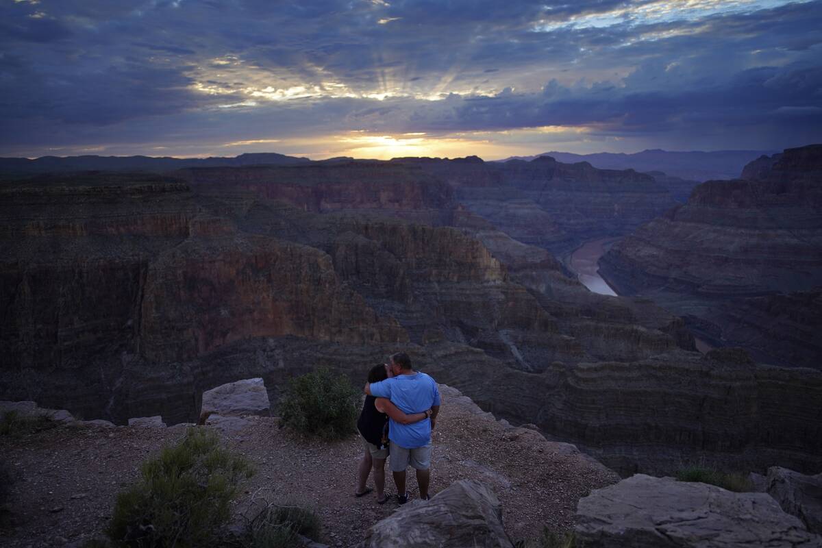 Alyssa Chubbuck, left, and Dan Bennett embrace while watching the sunset at Guano Point overloo ...