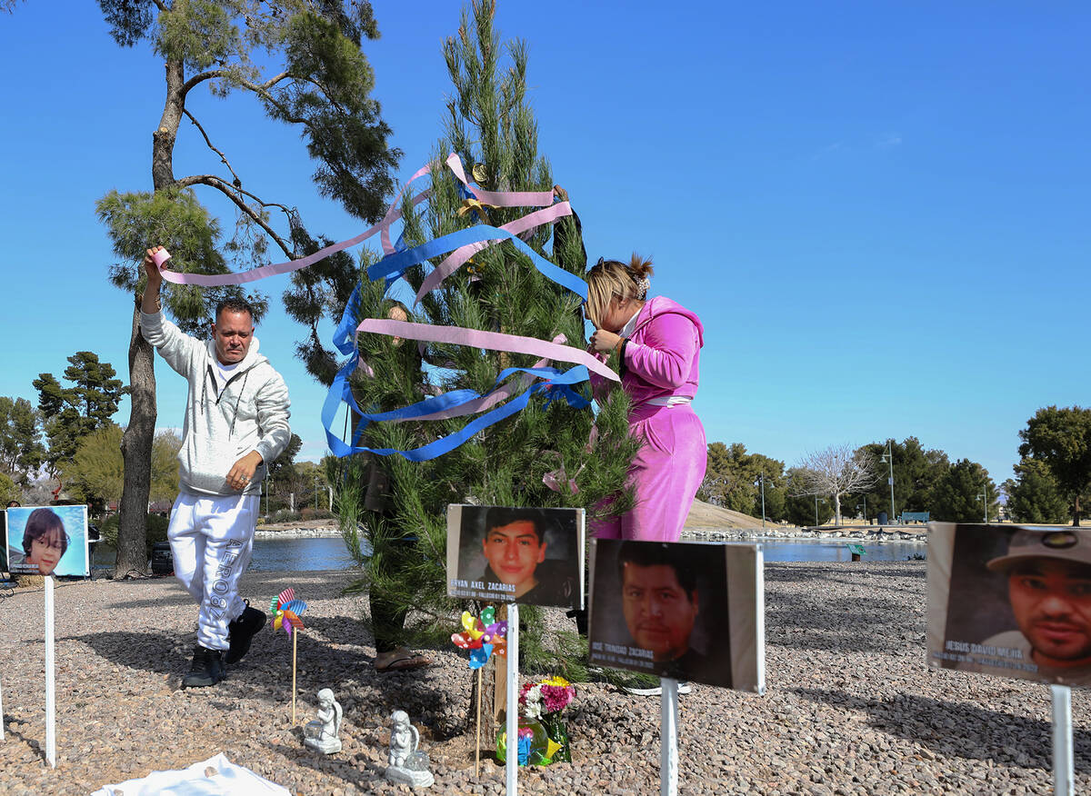 Jesus Mejia-Santana, left, along with family friend Stacee Rogers, right, decorates a tree plan ...