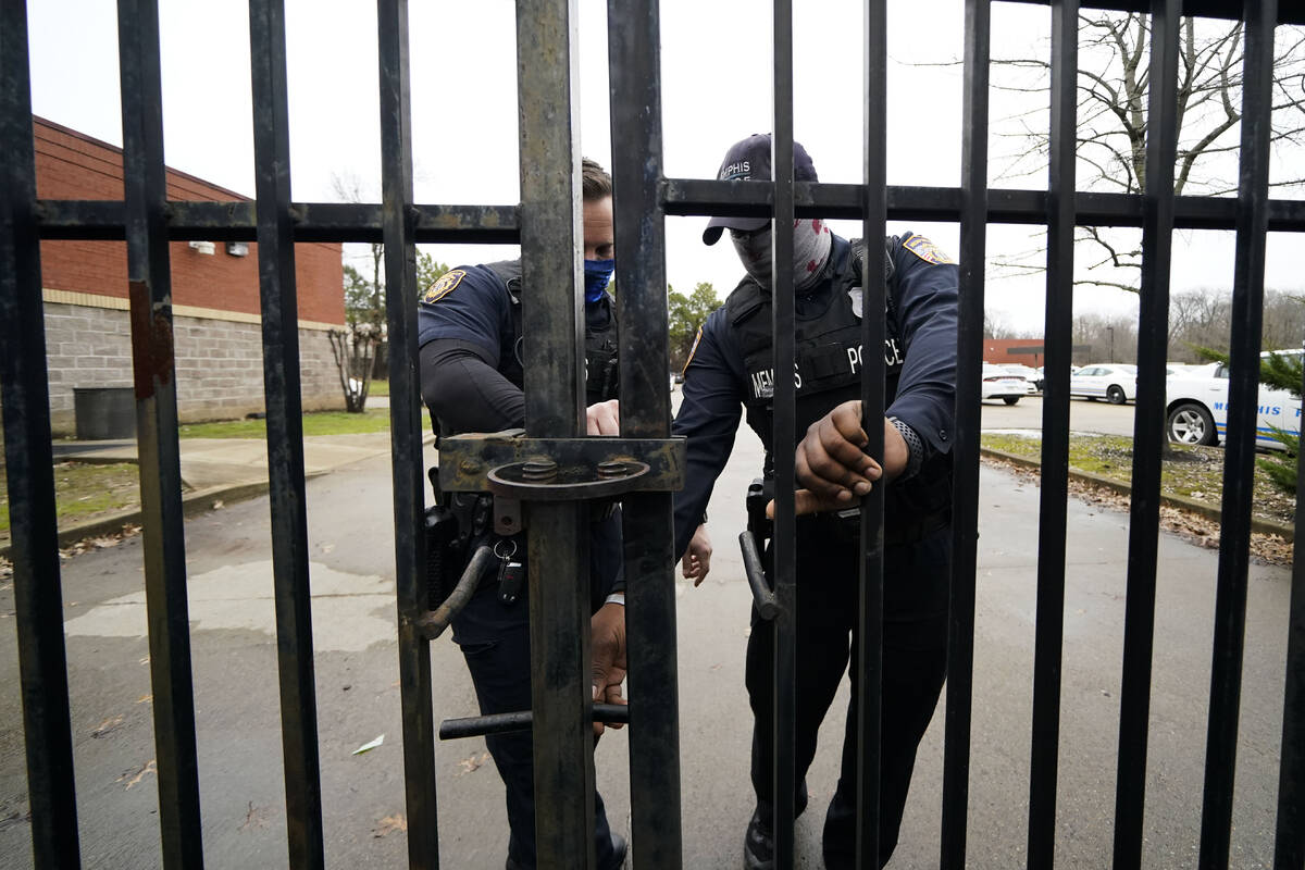 Memphis police lock a gate at a precinct as a group of demonstrators approach to protest the de ...