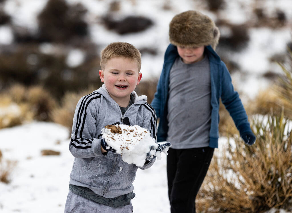 Jack Pettet, 8, and his twin brother, Oliver, both from England, play in the snow at the Red Ro ...