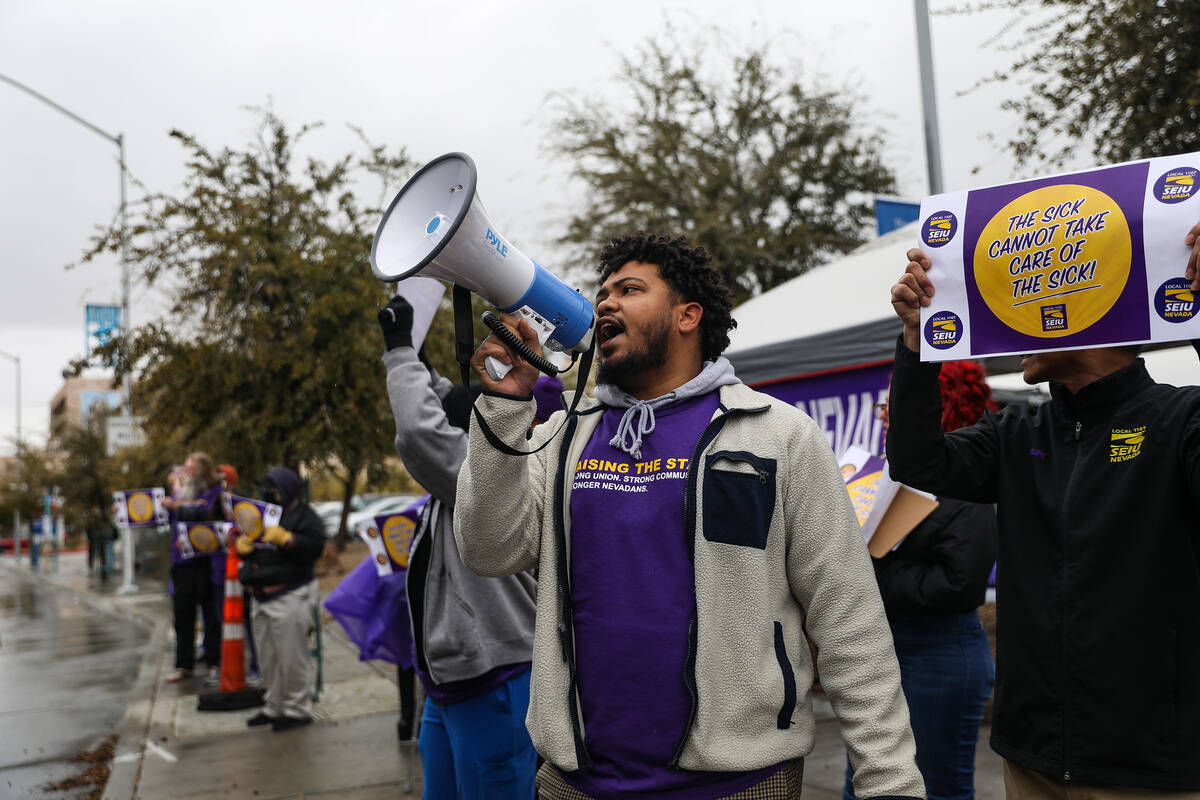 SEIU Local 1107 staff member Chris Hilton leads a group in chants as part of a picket in suppor ...