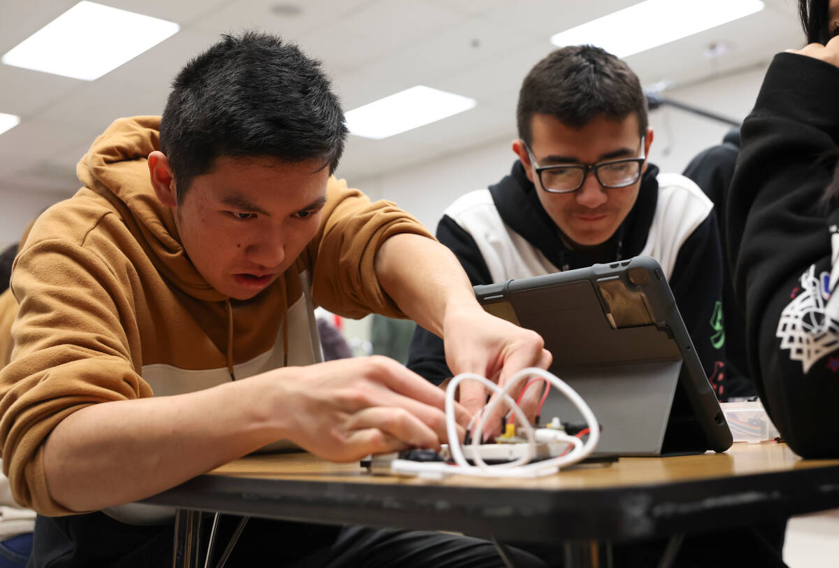 Senior James Phan, left, and sophomore Keoni Johnson work with circuits in a project during the ...
