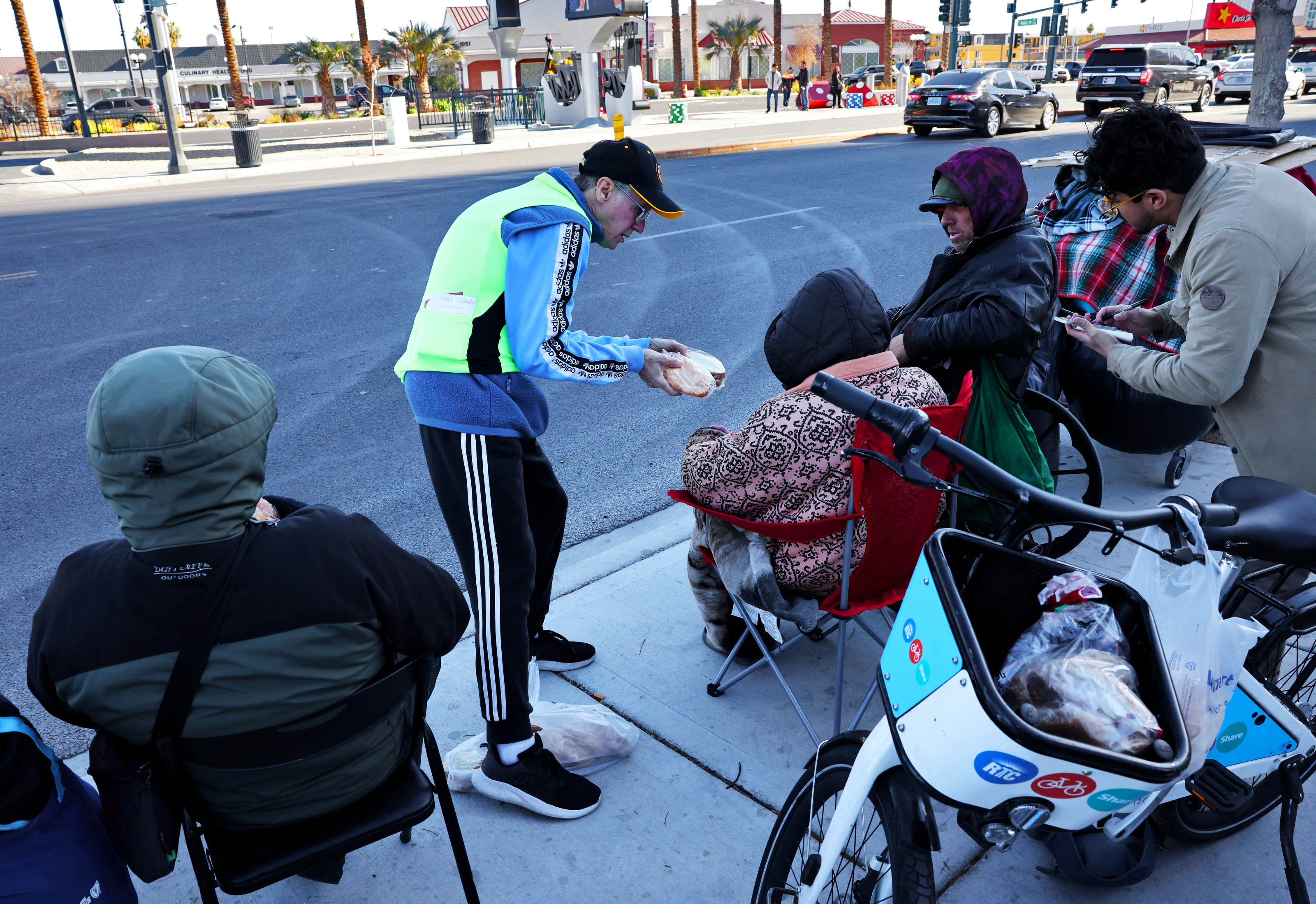 Seorang pria memberi makan para tunawisma di pusat kota Las Vegas