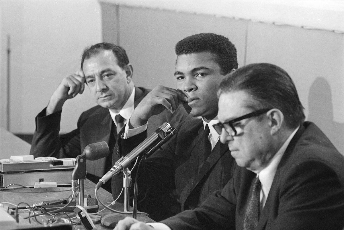 Heavyweight champion Muhammad Ali ponders a question during his news conference after his arriv ...